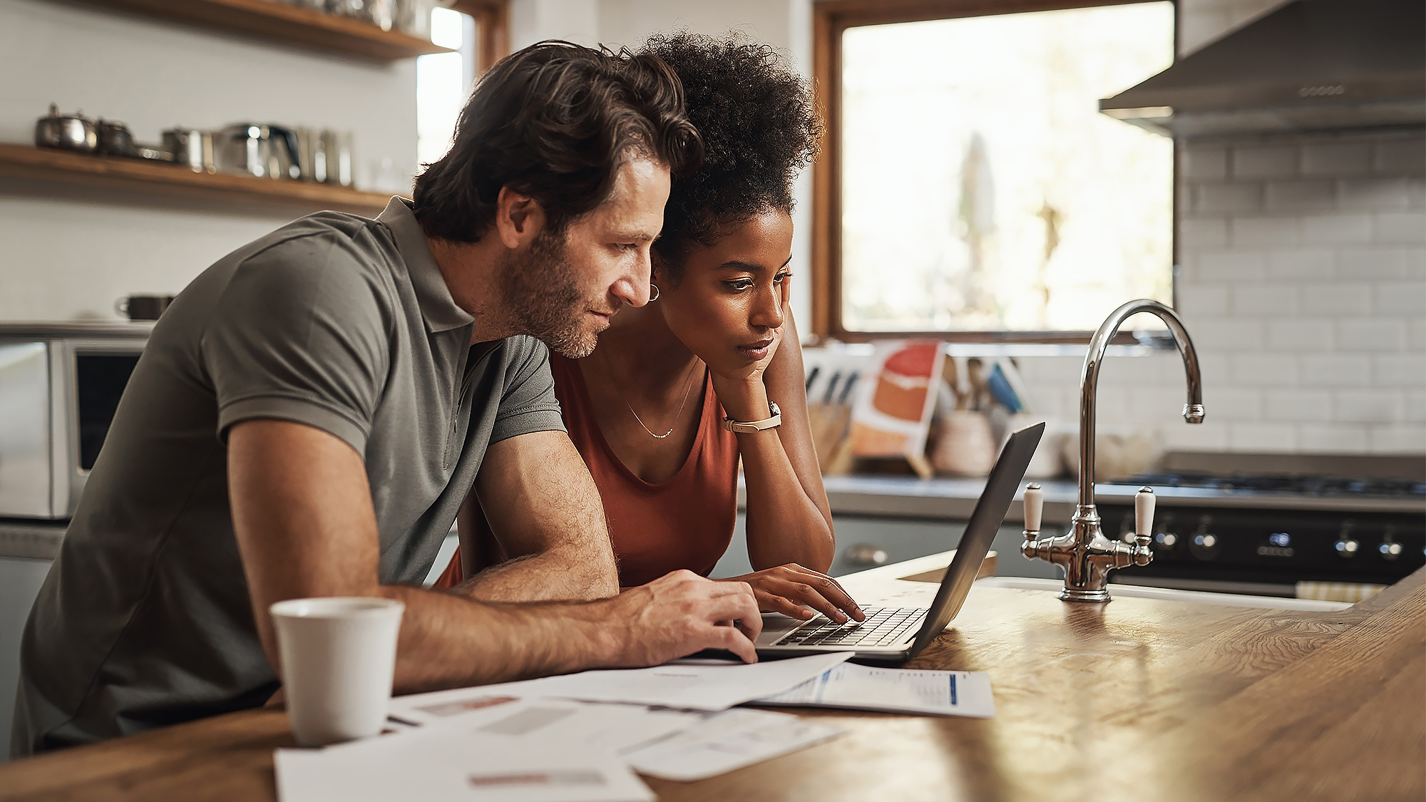 Couple marié consultant son ordinateur pour comprendre le prélèvement à la source et le taux individualisé 2025