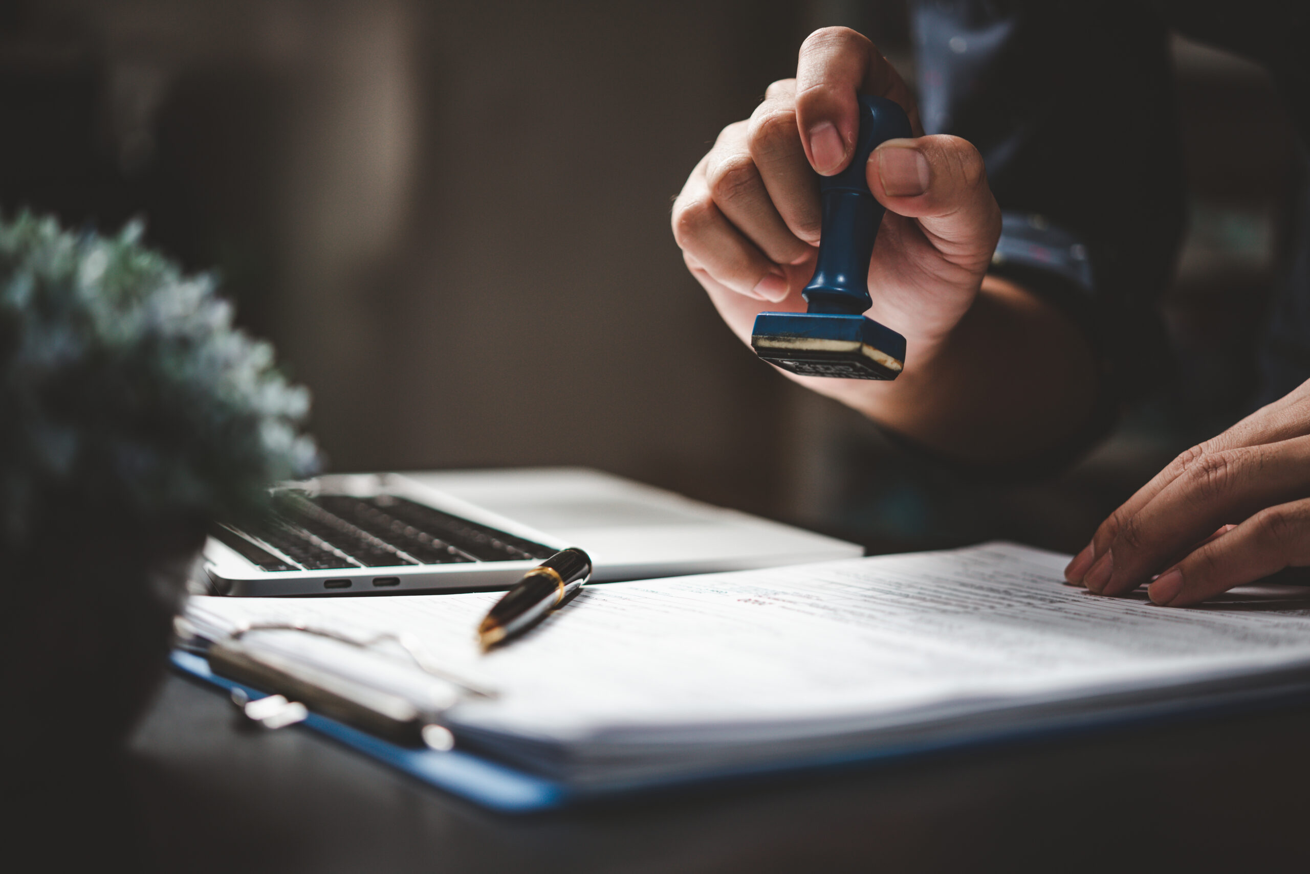 Man stamping approval of work finance banking or investment marketing documents on desk. conseil comptable nantes